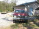 1989 Ford F-250 - This red Ford pickup truck is parked in a gravel driveway in front of a detached garage.