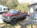 1989 Ford F-250 - This two-tone red and gray pickup truck appears to be a Ford F-250, but its body style suggests an earlier model year than 1989.