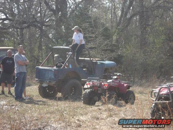 Off-road vehicles and people gathered in a wooded area