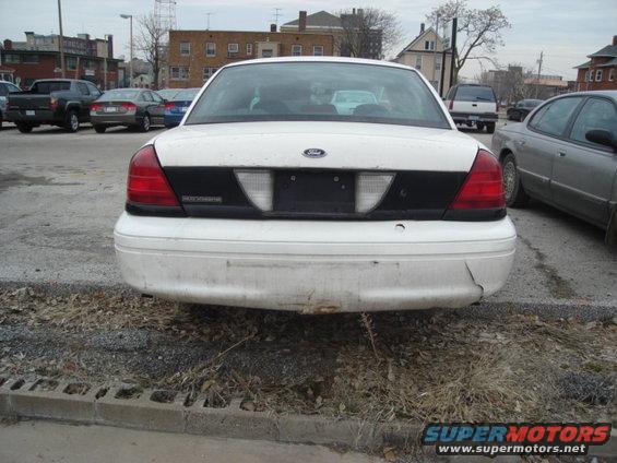 Rear view of a white 2000 Ford Crown Victoria with a black panel between the taillights