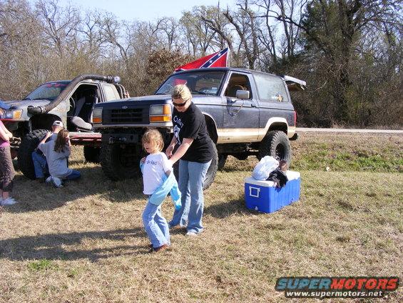 Dark blue Ford Bronco II with Confederate flag, parked next to another off-road vehicle