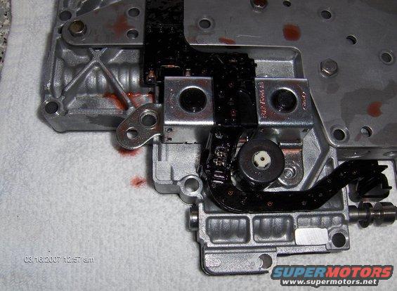 Transmission valve body with some red fluid visible