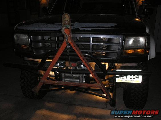 Front of a dark Ford F-Series truck with a tow bar and winch attached. License plate reads HOY 554