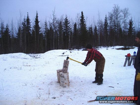 Man chopping wood in a snowy forest clearing