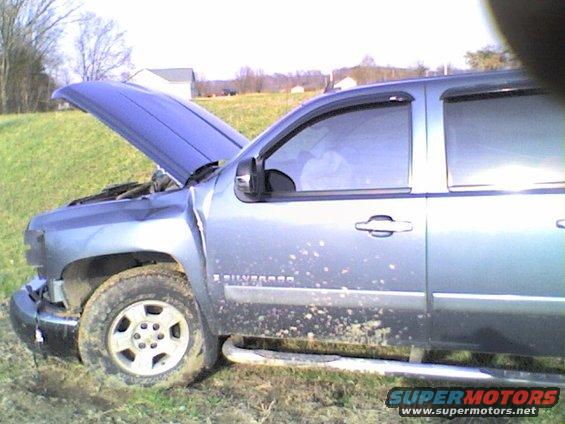 Silver pickup truck with hood open, mud splatters on side