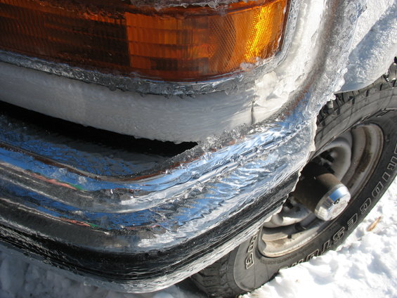 Ice-covered chrome bumper and headlight on a truck