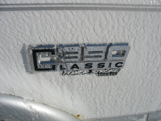 Close-up of a C350 Classic Power Stroke Diesel emblem on a white vehicle