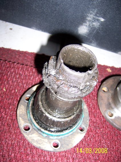 Damaged wheel bearing and hub assembly with grease and metal debris