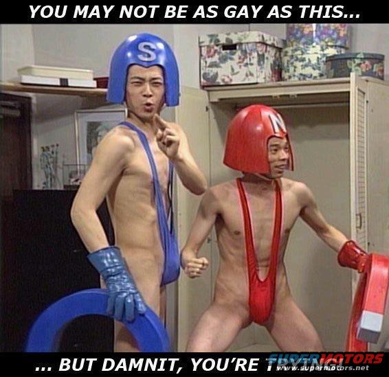 Two men in blue and red wrestling outfits with helmets, one pointing