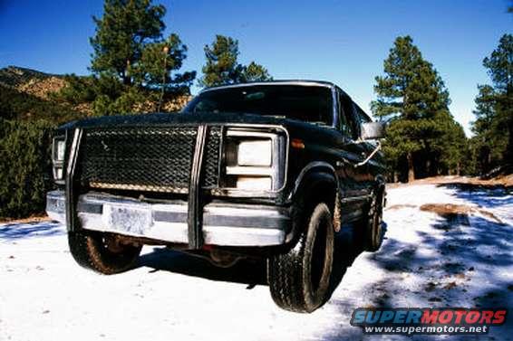 Black 1980 Ford Bronco with brush guard in snowy landscape