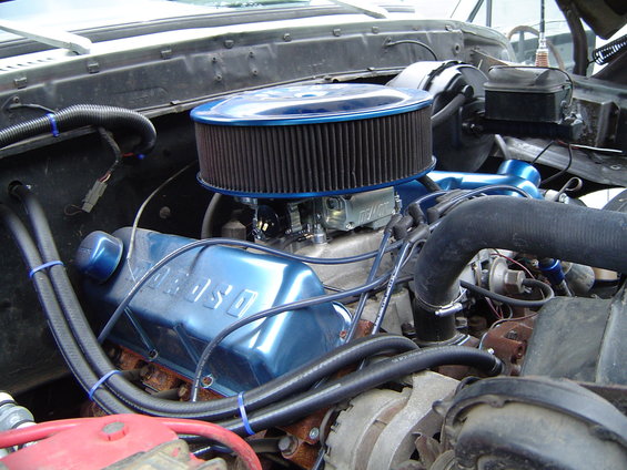 Engine bay with blue valve covers labeled "FORD", chrome air cleaner, and various hoses
