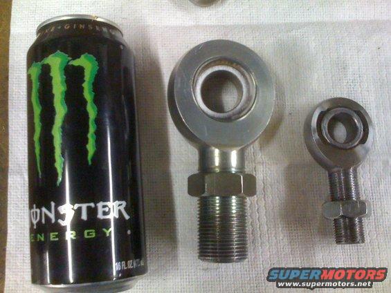 Monster energy drink can next to two metal rod ends of different sizes