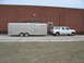 1995 Ford C-350 (Centurion Conversions) - A white 1995 Ford C-350 Centurion Conversions SUV is seen from the side, towing a large silver trailer.