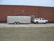 1995 Ford C-350 (Centurion Conversions) - Side view of a 1995 Ford C-350 (Centurion Conversions) SUV towing a silver trailer.