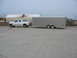 1995 Ford C-350 (Centurion Conversions) - Side view of a 1995 Ford C-350 SUV towing a large silver cargo trailer.