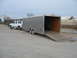 1995 Ford C-350 (Centurion Conversions) - A white SUV tows a large enclosed trailer with its rear ramp extended.