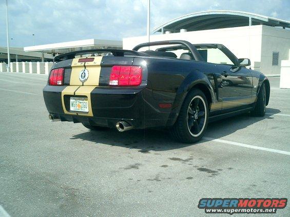 Black 2007 Ford Mustang convertible with gold stripes, rear view