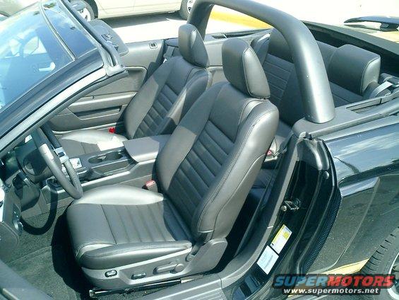 Black leather seats and dashboard of a convertible, viewed from the passenger side
