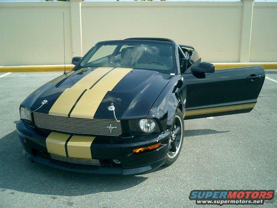 Black 2007 Ford Mustang convertible with gold stripes, driver's door open