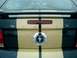 2006 Ford Mustang - The rear of a car displays 'SHELBY' lettering and a Ford Mustang emblem, with gold and black racing stripes.