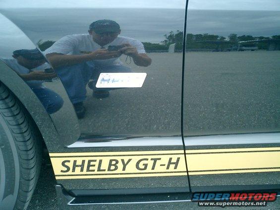 Black car side view with yellow Shelby GT-H stripe