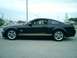 2006 Ford Mustang - Side profile of a black 2006 Ford Mustang Shelby GT-H with gold racing stripes.