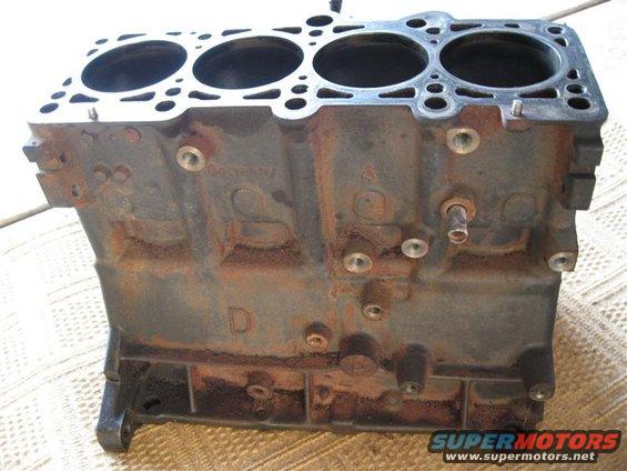 Cast iron engine block with four cylinders visible