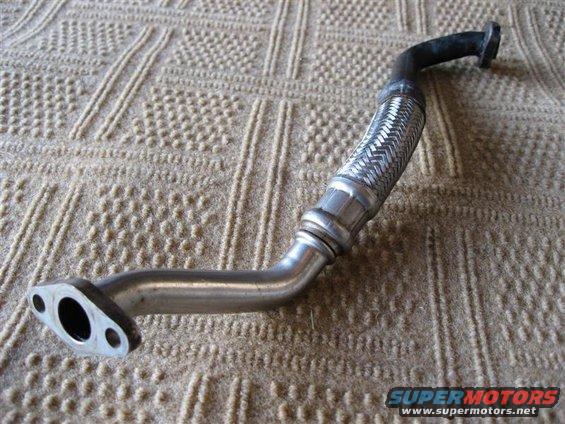 Exhaust flex pipe with flanges on both ends, laid on a textured surface