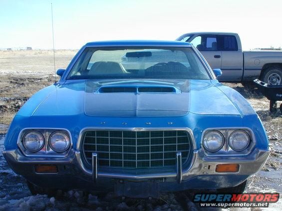 1972 Ford Ranchero front view with hood scoop and grille. Pickup truck visible in background