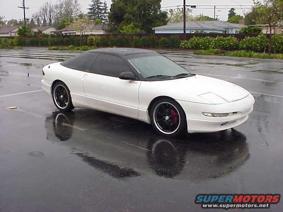White 1994 Ford Probe coupe with black roof, tinted windows, and aftermarket wheels