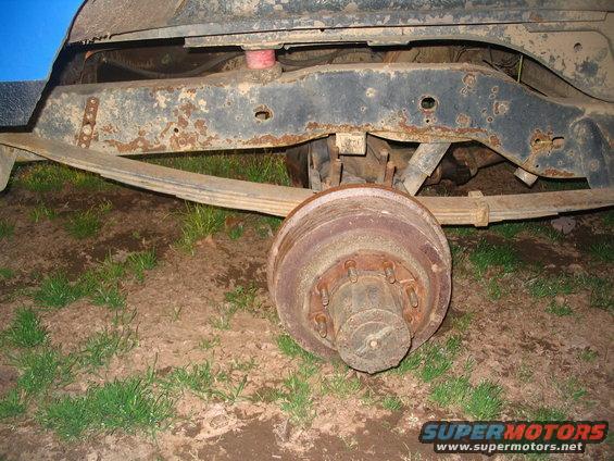 Rear axle drum brake assembly and leaf spring on a vehicle frame