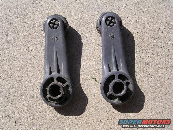 Pair of gray plastic window crank handles with ribbed knobs and circular mounting bases