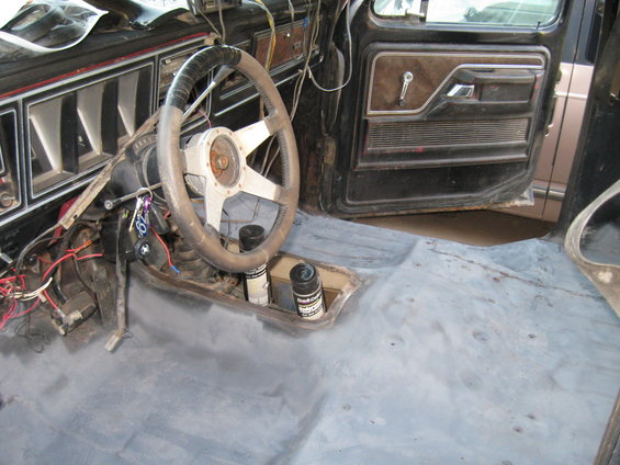 1978 Ford Bronco interior showing dashboard, steering wheel, door panel, and bare floor