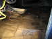 1978 Ford Bronco - The interior floor of a vehicle has been treated with black waterproofing material.