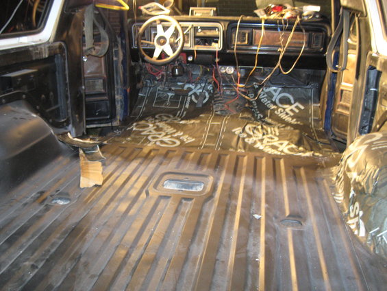 Interior view of vehicle with soundproofing on floor and exposed wiring