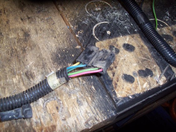 Wiring harness connector with colored wires (yellow, blue, green, pink) and black protective loom