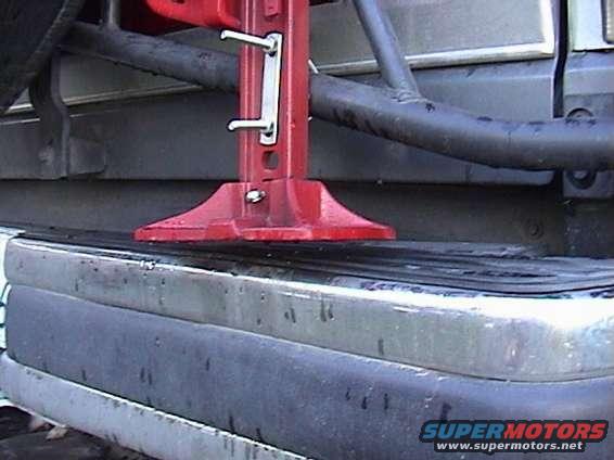 Red Hi-Lift jack attached to the bumper of a vehicle