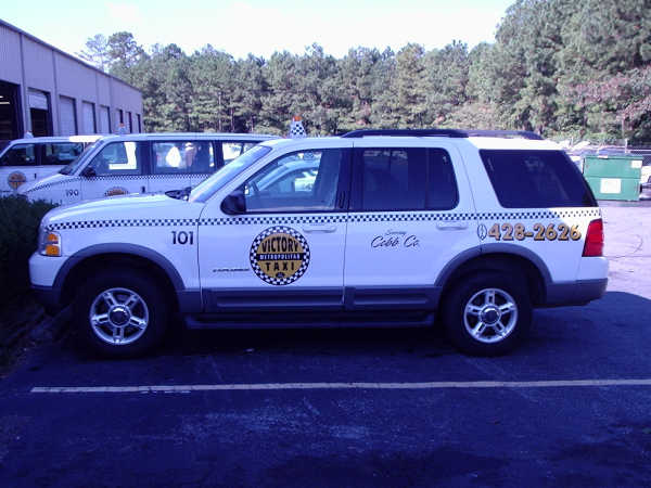 White SUV taxi with 'Victory Metropolitan Taxi' logo and phone number 0428-2626 on the side
