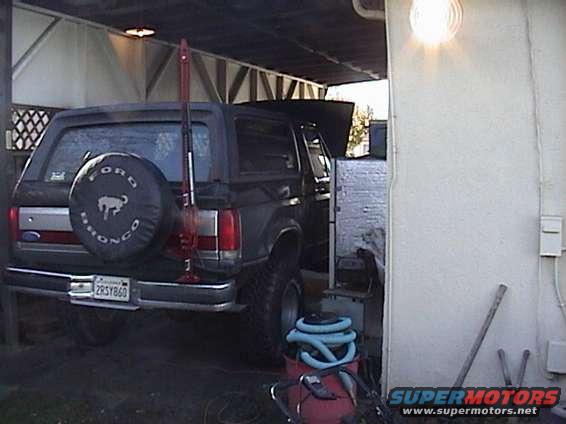 Black Ford Bronco rear view with a spare tire cover and a Hi-Lift jack mounted