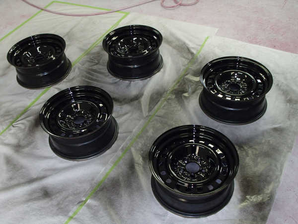 Five black steel wheels on a drop cloth
