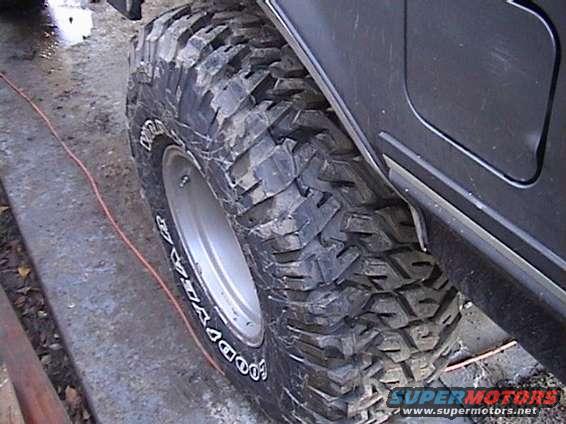 Black tire with "Goodyear" text and aggressive tread pattern on a dark vehicle fender