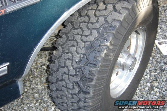 Dark teal fender and off-road tire on gravel