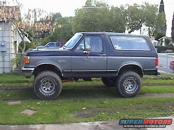 Gray 1990 Ford Bronco side view with lifted suspension and large tires