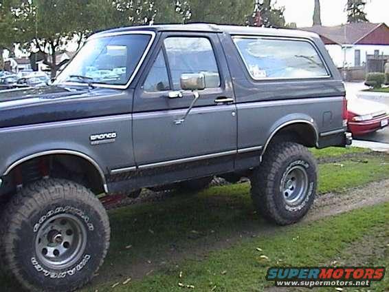 Dark gray Ford Bronco with lifted suspension and large tires, viewed from the front-right