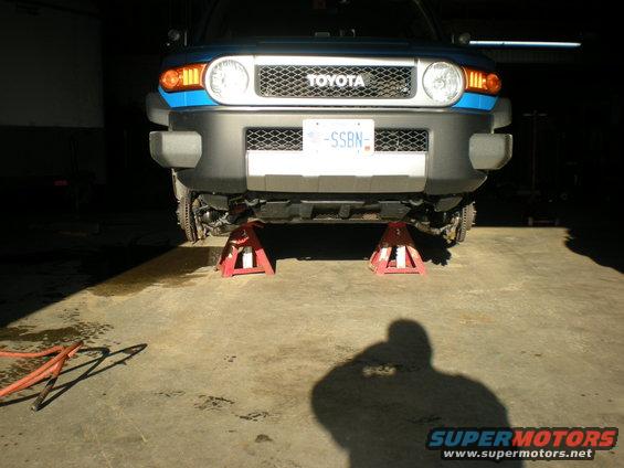 Blue Toyota FJ Cruiser on jack stands, front view