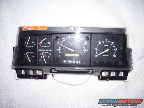 Dashboard instrument cluster with speedometer, tachometer, fuel gauge, and oil pressure gauge. Shows 'P RN 21' in the gear indicator