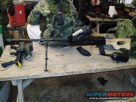 paintball marker with wooden stock and air tank on a table