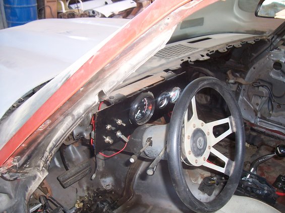 1979 Chevrolet Camaro interior with aftermarket gauges and steering wheel, showing dashboard and pedals