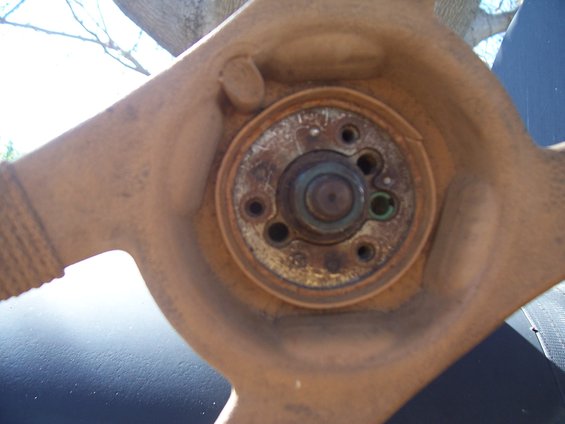 Rusty steering wheel hub with visible splines and mounting holes