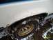 1988 Ford Bronco - This photo shows the rusty wheel well and tire of a white vehicle, partially covered in snow and mud.